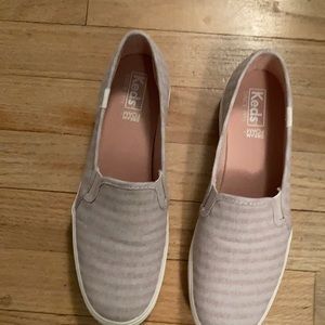 Dusty rose and beige striped Keds slip on shoes.